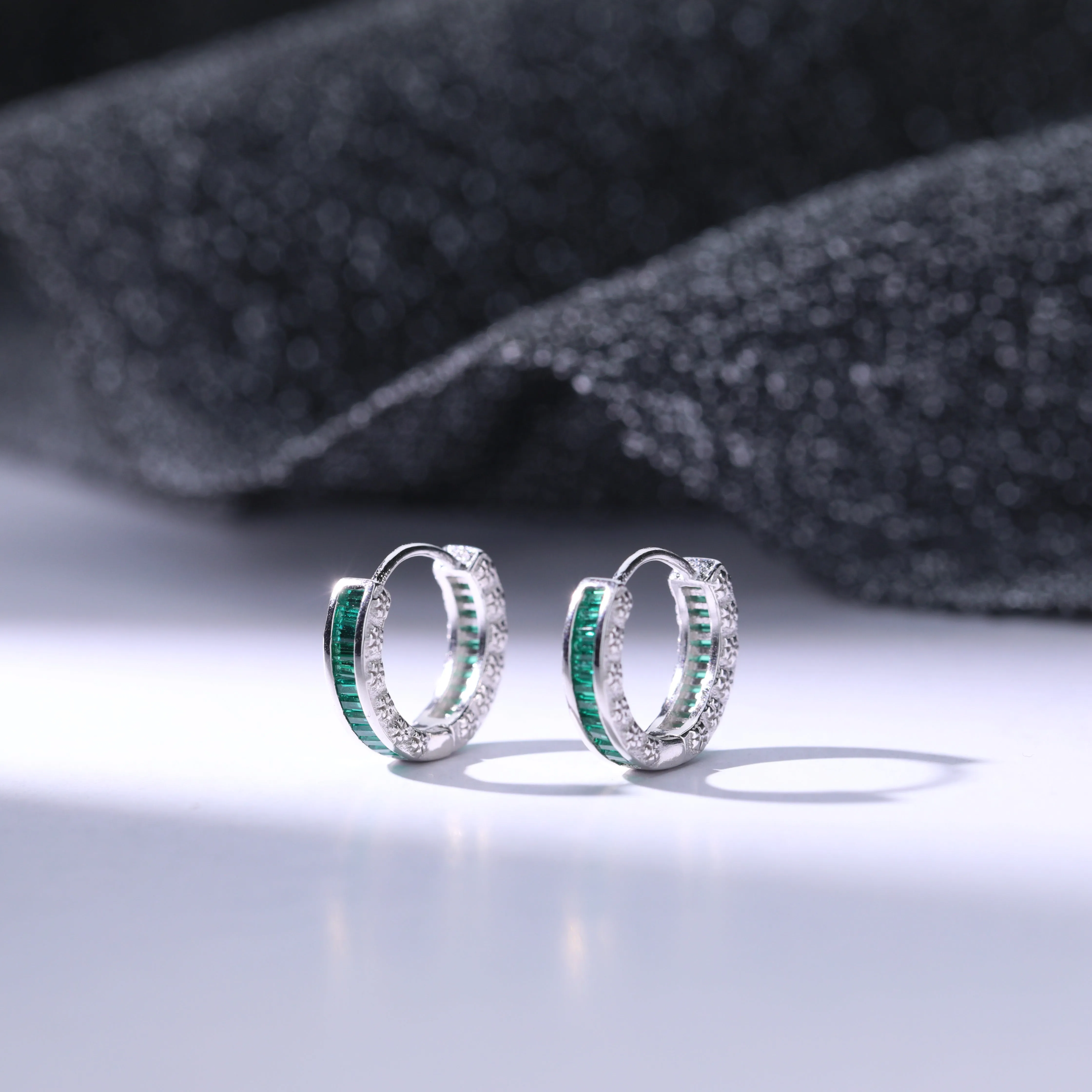 Aretes con diseo de argolla y zircona en color esmeralda